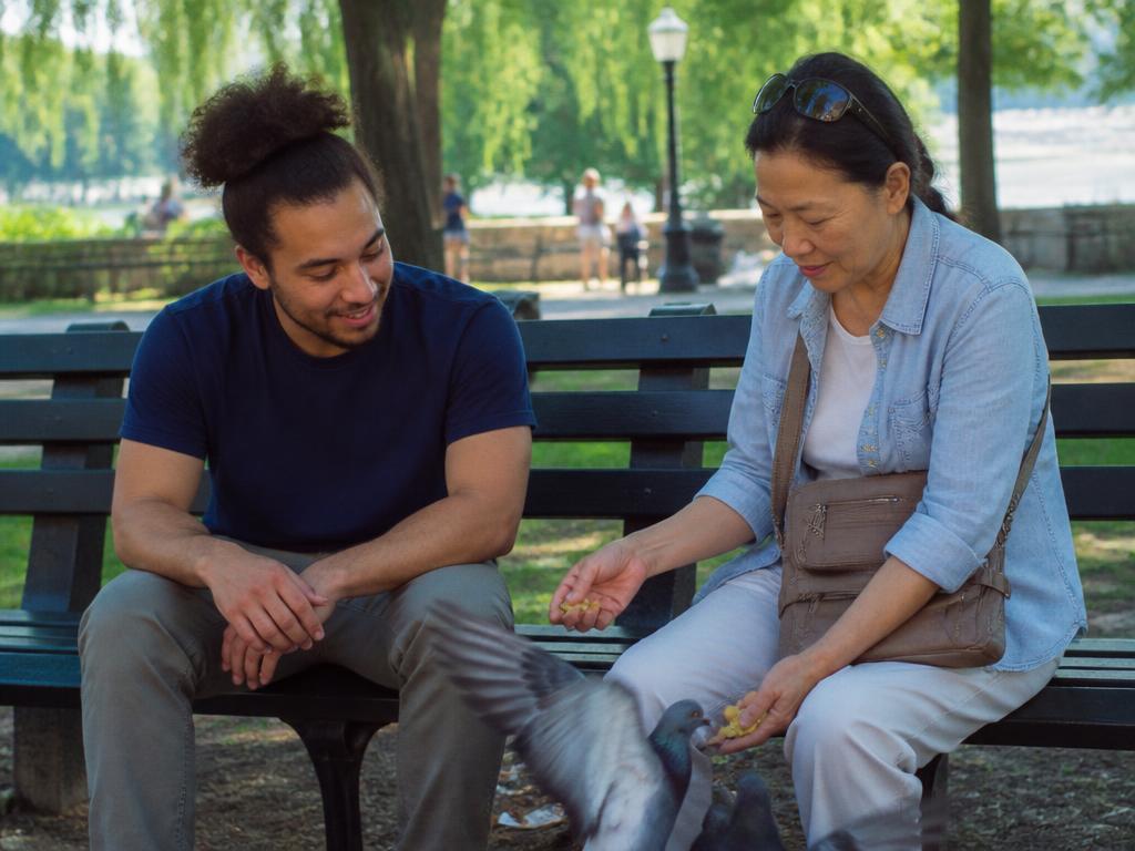 A person and support companion sitting together on a park bench in a quiet Eastern Iowa neighborhood